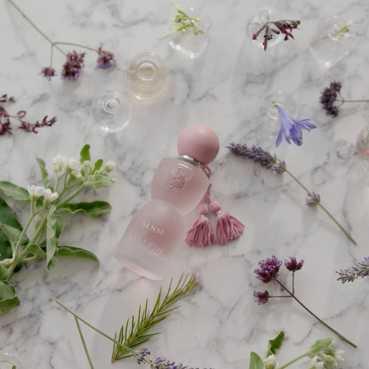 Perfum Sense Laverne ułożony na marmurowej powierzchni z kwiatami – elegancki, kwiatowo-piżmowy zapach dla kobiet